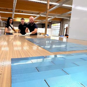 Bryan Mazor, CTO bei Source Energy, mit Kolleginnen und Kollegen am industriellen Schindel-Matrix-Stringer der Firma M10 Solar Equipment GmbH.(Bild:  M10 / Stéphanie Pigot)