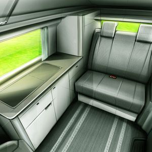 Küchenzeile und eine in Längsrichtung verschiebbare Sitzbank gehören zum Ausstattungsumfang des E-Campers.(Bild:  LEVC)