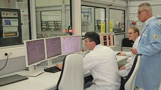 Martin Högner und Markus Toesko (ZF) erklären Johann Mathä (Yokogawa) den Prüfstand. Aus Sicherheitsgründen sind der Steuerstand und der Prüfstand durch eine Schutzwand getrennt. (Bild: ZF)