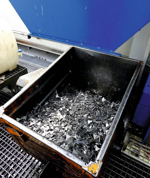 Das Restgitter des Bandes aus dem die Ronden geschnitten werden wird zerkleinert und fällt in einen Schrottbehälter a, der nach der Umformung entstanden Bart wird abgetrennt und fällt ebensfalls in einen Schrottbehälter b; das fertig tiefgezogene Bauteil wird über ein Förderband in den Gut-Behälter transportiert c. (Bild: Kuhn)