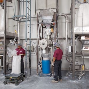 From each bulk bag unloader, particles are micronized in a vortex mill (at floor level), pneumatically conveyed into the product collector, and screened in the centrifugal sifter below it.