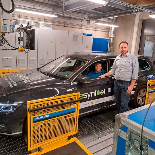 Im Auto sitzt Kfz-Techniker Florian Knoch, Kfz-Ingenieur Steffen Krajewski steht daneben: An der Hochschule Coburg führen sie die Tests auf dem Rollenprüfstand durch.(Bild:  Anja Singer/ Hochschule Coburg)