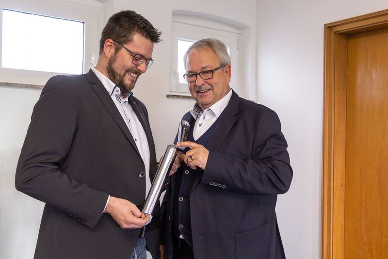Christoph Seibert zeigt Frank Höher eine verchromte Kunststoffsäule für einen Getränkeautomaten. (Wittmann Battenfeld)