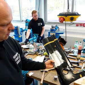 Steffen Fuchs, Referatsleiter Berufsbildung beim Zentralverband Karosserie- und Fahrzeugtechnik e.V., zeigt, was die Craft-Skill-Teilnehmer im Fall Karosserieinstandhaltungstechnik anfertigen bzw. bearbeiten durften.(Bild:  Dominsky – VCG)