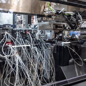 Maschinen verdrillen die Litzen und stecken die Pins automatisiert in Stecker. (Bild: Audi)