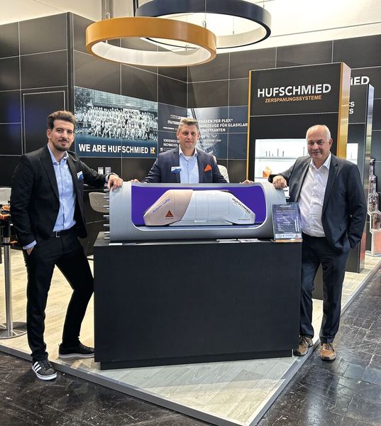 V. l.: Ender Murat Ferat, Product Manager Additive Manufacturing, und Kristijan Mikic, Expert Sales Manager Additive Manufacturing bei Krauss Maffei, zusammen mit Wolfgang Rinke, Business Development bei Hufschmied, und dem Hyperloop-Modell auf der Kunststoffmesse „K“ in Düsseldorf. (Bild: Hufschmied Zerspanungssysteme)