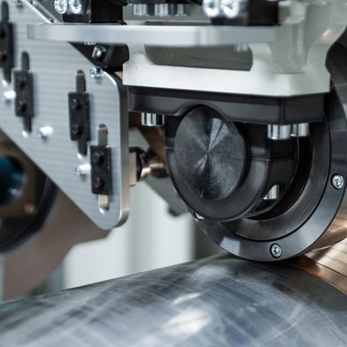 Das Fraunhofer IWS hat das neue Verfahren „Laserdirektplattieren“ entwickelt, das eine funktionale Schicht direkt auf dem Grundkörper erzeugt, indem ein bandförmiges Metall spiralförmig auf rotationssymmetrische Bauteile aufgebracht und lokal per Laser stoffschlüssig verbunden wird. (Bild: Christoph Wilsnack/Fraunhofer IWS)