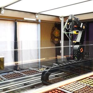 Der Chocomatic von Roose Automation ist ein echter Hingucker im Verkaufsbereich. Der Kunde steuert mit einem Tablet oder dem eigenen Smartphone einen Roboter, der aus einer Palette unterschiedlicher Pralinen individuell für den Kunden auswählt. 