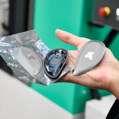 Wysokiej jakości powierzchnia osłony kluczyka radiowego, wykonanej z recyklingowanego tworzywa PC/ABS, powstaje dzięki technologii folii IMD oraz zastosowaniu matrycy strukturalnej. Wytłoczony w kształcie prostokąta element wtryskowy wraz z folią jest następnie frezowany na odpowiedni kształt końcowy na kolejnej stacji. (Bild: Arburg)