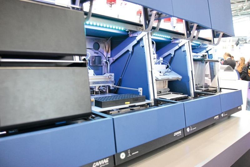 Automatisierte Dünnschichtchromatographie über Nacht ermöglicht diese Station mit derzeit vier Modulen von Camag. Aus dem Plattenlager (l.) werden die DC-Platten zur Probenapplikation transportiert, danach an die Entwicklungsstation übergeben und die aufgetrennten Proben schließlich bei der Derivatisierung (r.) mit geeigneten Markern (meist Fluorophore) versehen. Für 2025 sind noch Module zur Detektion sowie ein MS-Interface geplant. (Bild: VCG – C. Lüttmann)