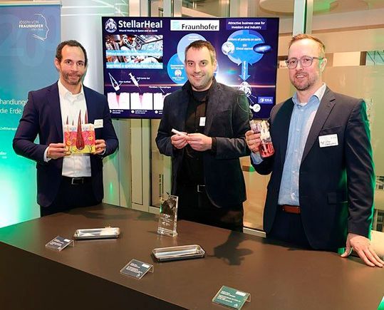 Dr. Dieter Groneberg, Dr. Bastian Christ und Prof. Nico Lachmann bei der Präsentation von StellarHeal auf der Auftaktveranstaltung zum Gedenkjahr „200 Jahre Josef v. Fraunhofer“ am 25. Februar 2026 in Berlin.(Bild:  Fraunhofer/Tom Maelsa)