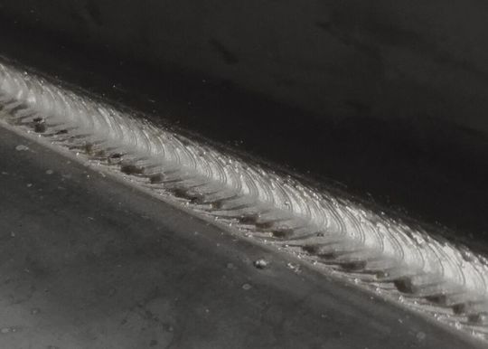 Blick auf den Übergangslichtbogen-Bereich, den der Wisesteel-Prozess hinterlässt. Der Baustahl wird dabei abwechselnd mit Kurz- und Sprühlichtbogen geschweißt, was dass schuppenartige Muster auf der Naht erklärt.(Bild:  Kemppi)