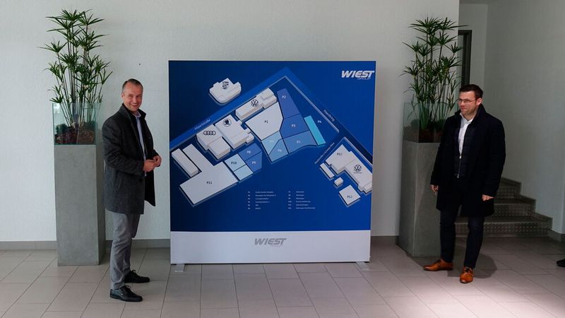 Das Betriebsgelände des Autohauses J. Wiest & Söhne in Darmstadt ist gigantisch. Der Händler vertreibt und repariert dort die VW-Konzern-Marken. Auf dem Geländeplan bekommt man davon eine ungefähre Ahnung. Ulf Büning-Pfaue (l.) und sein Kollege Christoph Schütz sind dort für den Service bzw. den Vertrieb verantwortlich. Dass die beiden zusammen da sind und die Jury bei ihrem Besuch begleitet haben, ist kein Zufall. Denn obwohl sich das Unternehmen in der Kategorie „Service“ beworben hat, … (Bild: Schreiner – VCG)