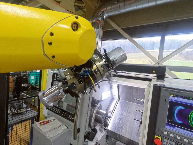 Für das effiziente Be- und Entladen der CNC-Drehmaschine verfügt der Roboter über einen Doppelgreifer. (Bild: Halter CNC Automation)