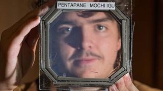 Abram Fluckiger holds up a sample panel square that has five sandwiched layers of a new material nearly transparent insulation material called Mochi, which was designed buy CU Boulder researchers in physics professor Ivan Smalyukh’s lab.
 (Source: Glenn J. Asakawa/CU Boulder)