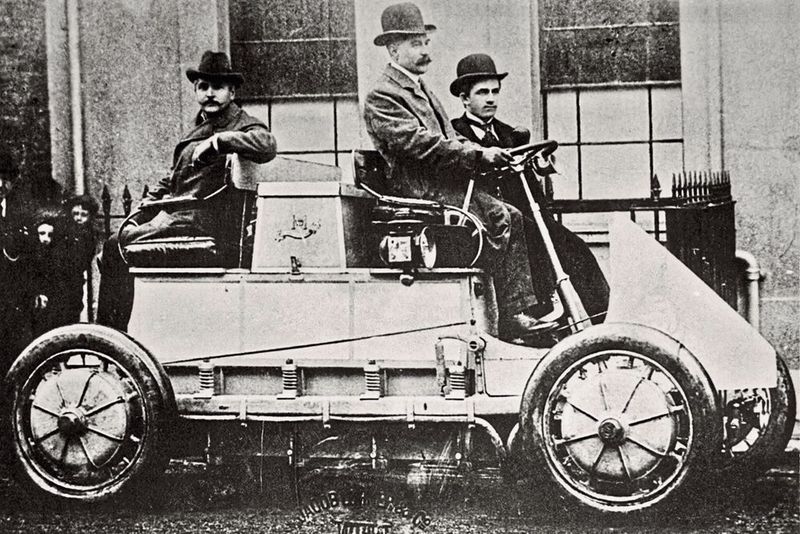 1900 – das erste Hybridfahrzeug: Hybridautos in der Vor-Prius-Zeit waren noch seltene Exoten. Dabei ist das Prinzip uralt: Das erste Hybridfahrzeug mit Verbrennungsmotor und elektrischen Radnabenmotoren war der Lohner Porsche – die Sensation auf der Weltausstellung 1900 in Paris. Die in den Radnaben der Vorderräder eingebauten Elektromotoren erbrachten eine Leistung von 2,5 PS bei 120 U/min. Der 44-zellige Akkumulator mit 300 Ah und 80 V erlaubte eine Fahrstrecke von 50 km pro Batterieladung; die maximale Geschwindigkeit betrug 50 km/h. Die niedrige Drehzahl des Elektromotors ermöglichte den Direktantrieb und den Einbau in das Rad. Der Motor arbeitete ohne Ketten und damit ohne mechanischen Kraftverlust. Dadurch erzielte der Elektromotor einen sehr hohen Wirkungsgrad und lief nahezu geräuschlos. Das Gesamtgewicht des Fahrzeuges betrug 1205 kg. Der Wagen konnte an allen vier Rädern gebremst werden, an der Vorderachse durch die Motoren und an der Hinterachse mit Hilfe einer Hand-Außenband-Bremse. (Bild: wikipedia.org/gemeinfrei)