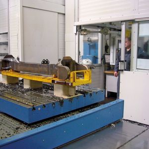 Ein Brückenkran hat eine komplette Schweißbaugruppe auf dem Maschinentisch platziert.