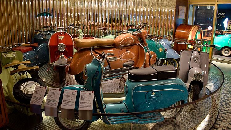 Auch diese bunte Rollersammlung aus der Nachkriegszeit ist in ein zeittypisches Ambiente eingebettet – typisch für das Ausstellungskonzept im PS-Speicher. (Foto: Rosenow)