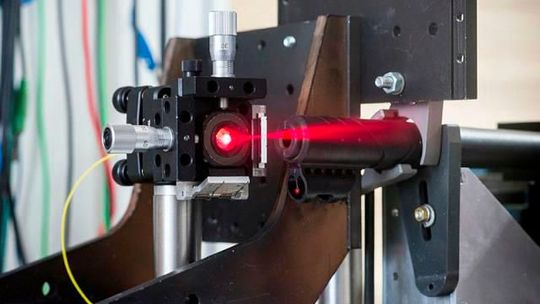 Demonstrationsaufbau einer ultraschnellen Distanzmessung: Der Lauf eines Luftgewehrs ist fest eingespannt und der beim eigentlichen Versuch unsichtbare Laserstrahl wird auf die Flugbahn der abgefeuerten Projektile ausgerichtet. Demonstrationsaufbau einer ultraschnellen Distanzmessung: Der Lauf eines Luftgewehrs ist fest eingespannt und der beim eigentlichen Versuch unsichtbare Laserstrahl wird auf die Flugbahn der abgefeuerten Projektile ausgerichtet.