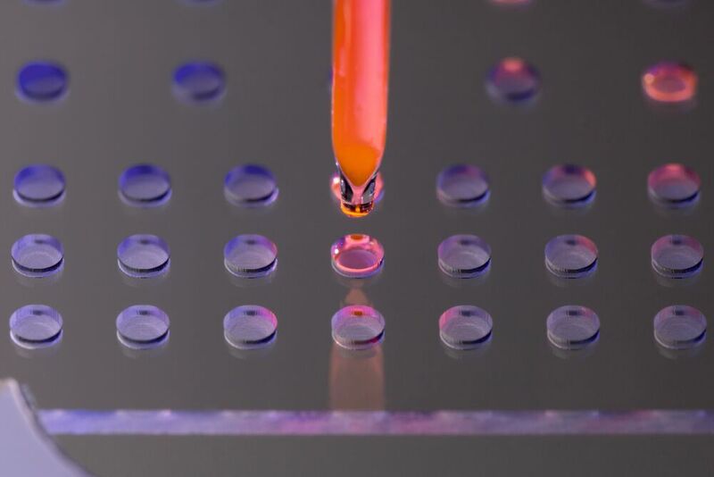 Abb.2: Arralyze nutzt Glaskavitäten, auch Wells genannt, mit sehr geringen Probenvolumina im Bereich von Pikolitern bis Nanolitern. Hier wird eine fluoreszierende Testlösung hochpräzise in ein Glas-Array gedruckt. (Bild: LPKF Laser & Electronics AG)