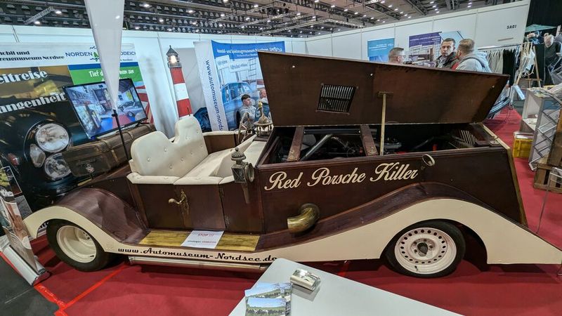 Der andere rote Porsche-Killer: Die Karosserie des „Holz Royce“ besteht vorrangig aus alten Spanplatten. Die Erbauer Gordon Weiss und André Simon aus Neustadt in Holstein haben das Holzauto beim Biertrinken aus einer Laune heraus entwickelt und folgten damit dem Aufruf vom Kieler Kneipenwirt „Holgi“ 2019, der Gegner suchte, die gegen ihn und seinen „Red Porsche“ auf einer Strecke von 200 Metern antreten.  (Bild: Dominsky – VCG)