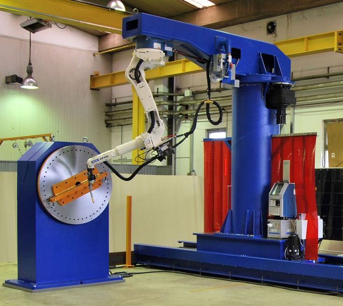 OTC 10-Achs Roboteranlage bestehend aus: Fahrwerk mit 180° Schwenkportal, kopfüber schweißendem Roboter und 2 Stück 6-To- Drehpositionierer.  (Bild: OTC Daihen)