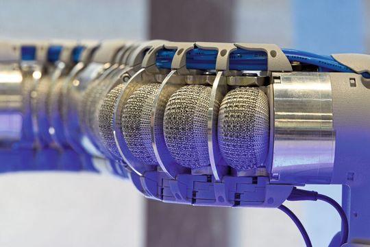 Wie eine Kette kleiner Muskeln reihen sich die mit einem Textil ummantelten Bälge der pneumatischen Balkgsegmente aneinander. Der Leichtbauarm eignet sich für die Mensch-Roboter-Kollaboration.(Bild:  Stefanie Michel)