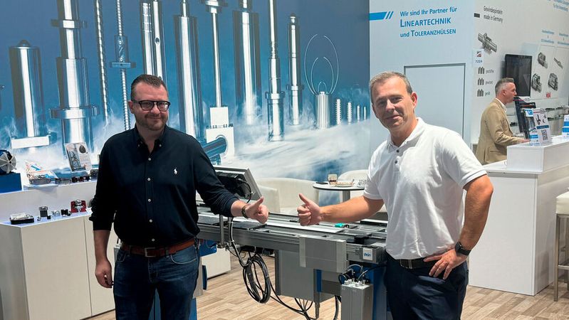 Fabian Fürber und Martin Magrian (v. l.) zeigen auf der Motek 2023 das Stein-Transfersystem mit den Komponenten von Dr. Tretter.(Bild:  Dr. Erich Tretter, Maschinenelemente/Stein Automation)
