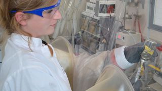 Dr. Corinna Bang entnimmt archeelle Kulturen aus einer Serumflasche. Dieser Prozess findet unter Ausschluss von Sauerstoff in einem anaeroben Zelt statt. (Bild: Claudia Eulitz, CAU)