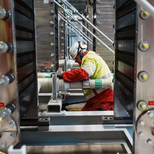 Die letzten Zentimeter sind Handarbeit: Monteure verbinden die einzelnen Elektrolyseur-Module miteinander. Bei Fertigstellung werden insgesamt 72 „Stacks“ eine Kapazität von 54 Megawatt haben.(Bild:  BASF)