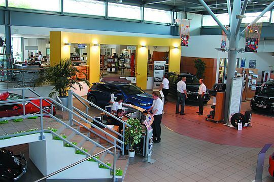 Freundliche Servicemitarbeiter empfangen die Autohausbesucher am Infostand im Kundenzentrum und führen sie zu den entsprechenden Abteilungen. (Rubbel)