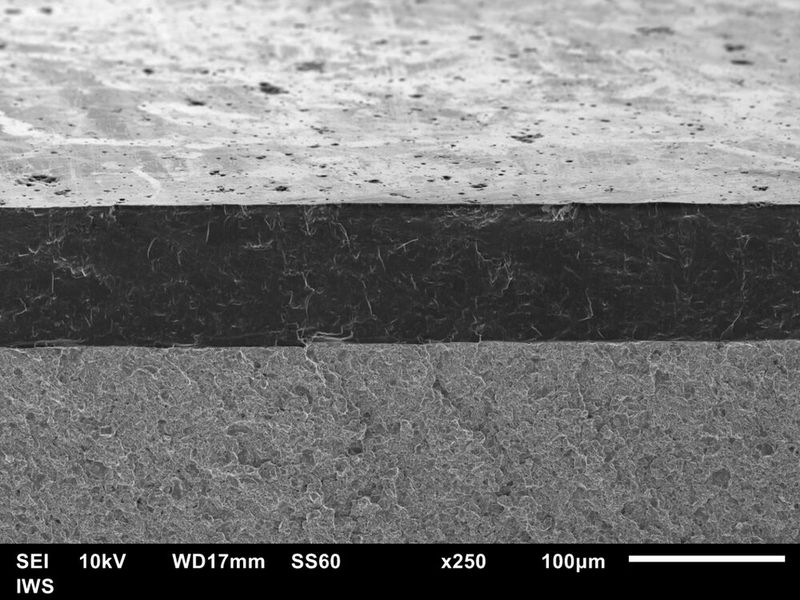 Ultradicke „ta-C“-Schicht von etwa 100 Mikrometern Schichtdicke nach ihrer Glättung. Schrägansicht auf die Bruchfläche im Rasterelektronenmikroskop.  (Bild: Fraunhofer IWS)