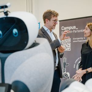 Prof. Annette Diefenthaler und Prof. Alexander König diskutieren über den neuen Assistenzroboter. Forschungszentrum Geriatronik, Garmisch.(Bild:  Max Merget)
