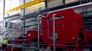 Szene aus dem neuen Film zur Modernisierung des Kraftwerks: Die Dampfturbine mit Generator an ihrem Standort im Kraftwerk: für Einbau und Anschluss an das bestehende Rohrleitungsnetz war eine enge und detaillierte Abstimmung zwischen ISG Engineering, ISGT und dem Kraftwerkbetreiber Ver- und Entsorgung nötig. Die Rohre im Bild sind eine Animation, da zum Zeitpunkt der Aufnahme die Anschlussarbeiten noch nicht abgeschlossen waren. (Infraserv Gendorf)