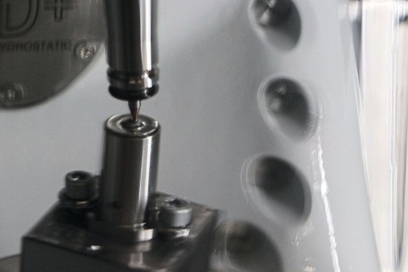 Ein komplexer Bearbeitungsvorgang, der auch bei dem fürs Foto abgestellten Kühlschmiermittel (B05b) nur leicht verschwommen erkennbar ist. Am Ende steht ein hochpräziser Auswerfer-Kern mit konischer Bohrung(Bild:  Kern Microtechnik GmbH)