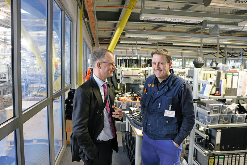 Durch eine dicke Glaswand getrennt sind Produktion und Testlabor (links) von den Ingenieursarbeitsplätzen. Betriebsleiter Igor Iraeta (r) erklärt Chefredakteur Frank Jablonski die Abläufe.  (Jablonski)