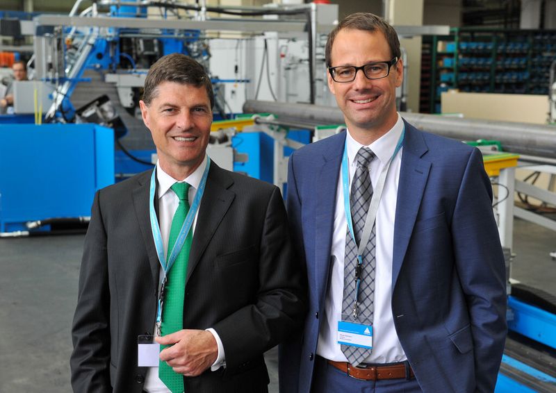 Gerhard Glanz (CEO, links) und Oliver Reimann (CSO) vor der neuen Maschine AFPM (Automatic Flexible Pole Machine). (Bild: Indeed/Simon Bierwald)