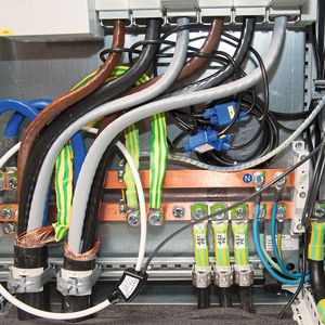 Bild 5: Rogowski-Spulen lassen sich leicht nachträglich installieren – auch wenn es eng wird. Die schwarzen Spulen oben in der Bildmitte erfassen die Ströme der einzelnen Phasen. Die weiße Spule links dient zur Differenzstrommessung.(Bild:  M. Witzsch)