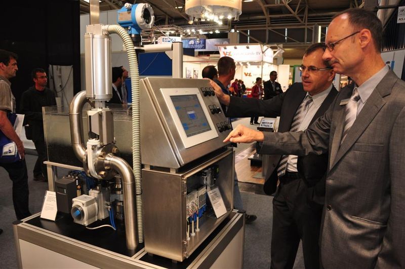 Dr. Roos, Leiter Prozessautomation bei Festo, und Dr. Wolfgang Rieger, Key Account Manager bei Festo, erklären auf der IFAT anhand eines Exponats die Vorteile der pneumatischen Automatisierung von Wasseraufbereitungsanlagen. Für die Messe wurde eine Automatisierungslösung im kleinen Maßstab nachgebaut, die derzeit in Ägypten in Betrieb genommen wird. (Archiv: Vogel Business Media)