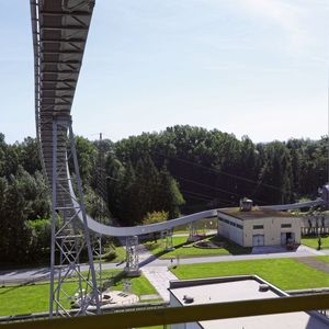 Mit dem U-Förderer lassen sich engere Kurvenradien als mit einem Muldengurtförderer und höhere Massenströme als mit einem Rohrgurtförderer umsetzen.(Bild:  Beumer Group)