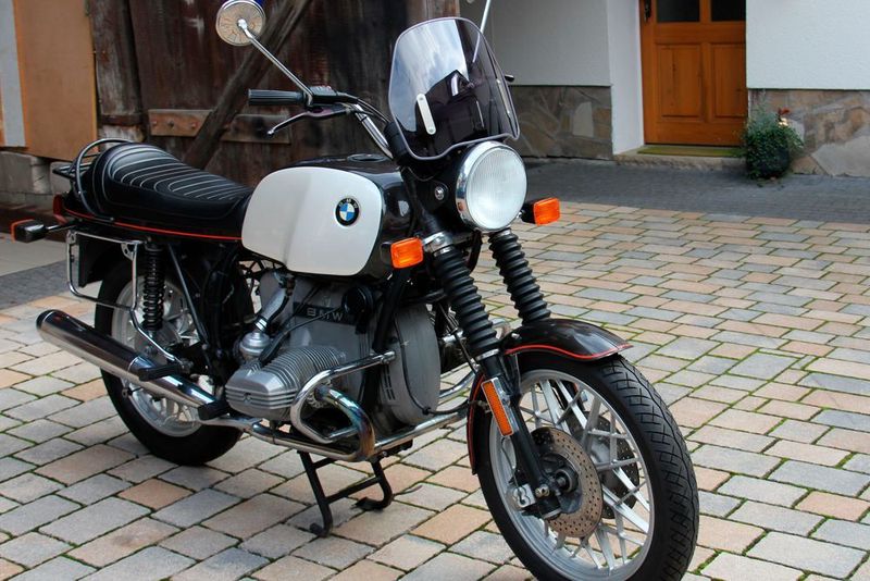 Im April 1980 wurde die BMW R 80 zum ersten Mal zugelassen. Damals mit einer Spitzengeschwindigkeit von 165 km/h keine Rakete, aber mit der kleinen Frontscheibe und den groß dimensionierten originalen BMW-Koffern eine bequeme Reisemaschine für die entspannte große Tour. Der luftgekühlte Zweizylinder-Boxermotor aus der Modellreihe 247 leistet 50 PS bei 7.250 U/min aus 785 ccm. (Lebenshilfe)