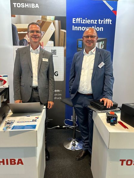 (V. l.) Ralf Handschuhmacher und Michael Heidler schwenken die Fahne der TOSHIBA auf dem Event. (Bild: Vogel IT-Medien)