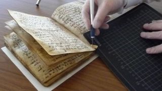 Ein Experte entnimmt der Koranhandschrift eine Probe für die Datierung. Foto: Dr. Wilfried Lagler/Universitätsbibliothek Tübingen. (Bild: Dr. Wilfried Lagler/Universitätsbibliothek Tübingen)
