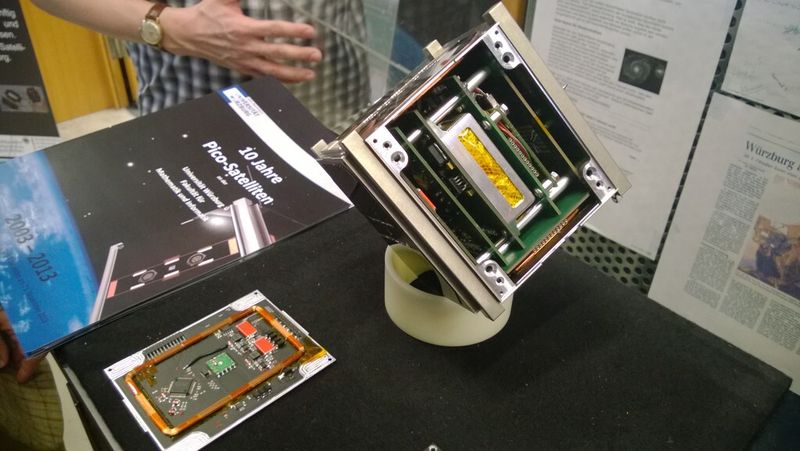 Modular aufgebaut: UWE-3 (r.) beherbergt mehrere Subsysteme, die auf einer Backplane aufgesteckt sind. Links im Bild ist eine der Magnetmomentspule zu sehen, die auf der Rückseite der Außenflächen angebracht sind. Mit ihrer Hilfe richtet sich der Kleinstsatellit am Magnetfeld der Erde aus. (Bild: konstruktionspraxis/Jan Vollmuth)