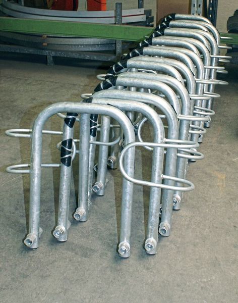 Die Abbildung zeigt den Hauptbügel der Fahrradparker Beta-Classico mit einseitiger Tiefeinstellung, Rohrverbinder und Lackschoner – ein Produkt von Orion. Dieses Bauteil wird auf dem Sägeautomaten und dem Bohrautomaten CTM von Bomar bearbeitet. (Give 4 PR)