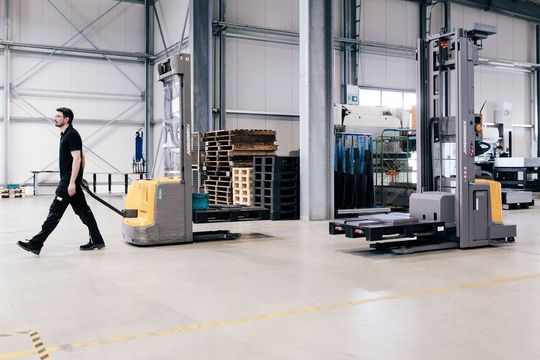 Ein Mitarbeiter transportiert Material in einer Fertigung. Mithilfe der Software Coriva lassen sich alle Systeme orten, die mit dem offenen Lokalisierungsstandard Omlox kompatibel sind.(Bild:  Cornelius Bierer)