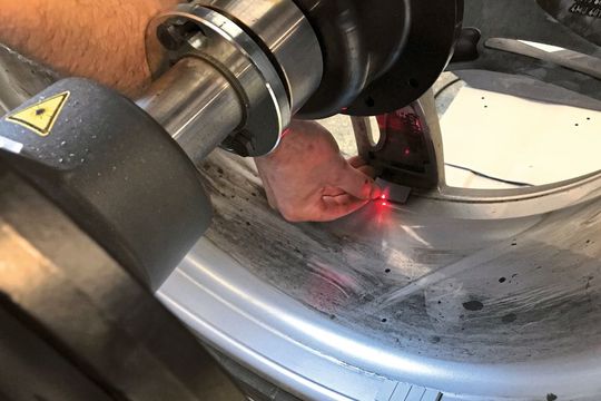 Der Punktlaser zeigt dem Monteur die exakte Mitte der Position des Auswuchtgewichts. Die unauffällige Platzierung hinter der Speiche ist kein Zufall – hier wird im Splitmodus gewuchtet.(Bild:  Holz / »kfz-betrieb«)