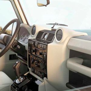 Die schwarz glänzende Mittelkonsole beherbergt das Land-Rover-Classic-Infotainment-System. Über den mit einer Blende eingefassten 3,5-Zoll-Touchscreen steuert man Funktionen wie Navigation, DAB-Radio und Bluetooth-Verbindungen.(Bild:  JLR)