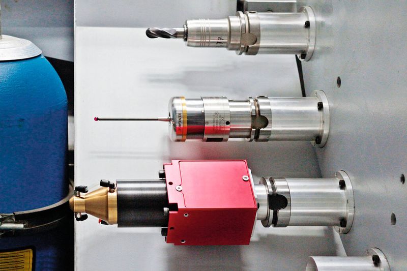 Bild 1: Blick in das Werkzeugmagazin der HSTM-Maschine: oben ein normales Fräswerkzeug, in der Mitte ein Messtaster und unten die Laserschweißeinheit mit rotem Grundkörper. (Bild: Hamuel)