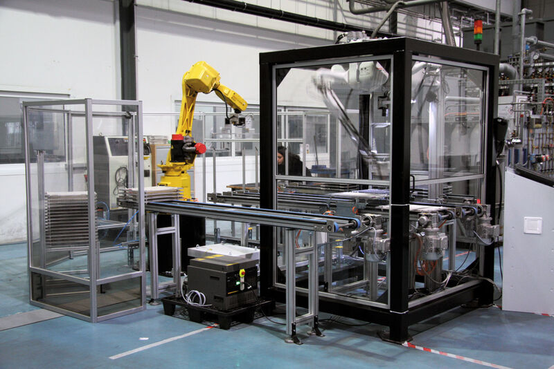 Vue sur l’installation avec un robot à bras articulé (à gauche) et les robots Delta dans des châssis protecteurs fermés qui traitent 600'000 plaquettes de coupe (à droite) par mois. (Image: M. Böhm)